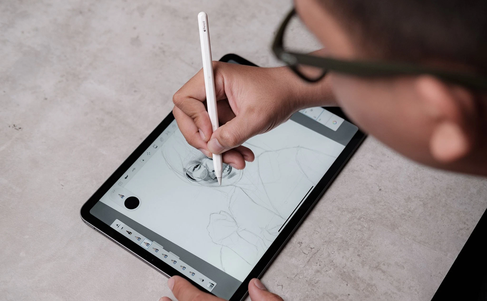 tay đang vẽ bằng bút stylus trên màn hình laptop cảm ứng